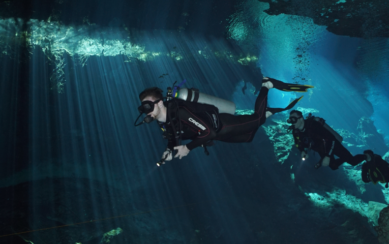 The author scuba diving in a beautifully lit cave